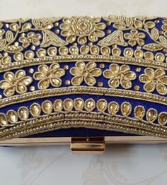 This EIRA Clutch is a stylish and unique accessory. Crafted with intricate embroidery in an eye-catching design, it's a sophisticated and versatile piece for your wardrobe. Perfect for adding a touch of flair to any outfit! Approximate Size: 20cm (L) x 4cm (W) x 12cm (H) Elegant Embroidered Fabric For Festive Occasions, Elegant Intricate Embroidered Fabric For Festive Season, Elegant Embroidered Fabric For Diwali, Elegant Embroidered Fabric For Diwali Festivities, Elegant Festival Embroidered Fabric, Elegant Embroidered Fabric With Handwork, Elegant Embroidered Fabric With Zari Work On Silk Thread, Elegant Embroidered Fabric With Handwork For Festive Occasions, Elegant Embroidered Silk Fabric With Zari Work