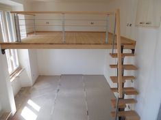 an empty room with wooden stairs and white walls