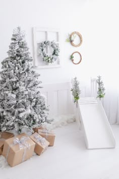 a white christmas tree with presents in front of it