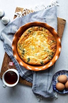 an omelet is sitting on a table next to some eggs