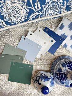 some blue and white items sitting on a bed next to each other with tags in front of them