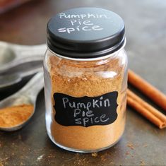 a jar filled with pumpkin pie spice next to cinnamon sticks