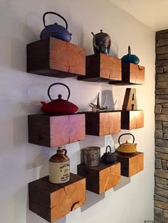 three wooden shelves with teapots and other items on them hanging from the wall