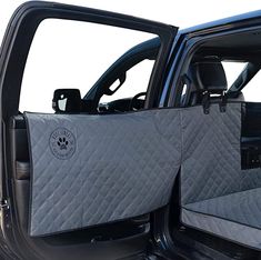 the interior of a vehicle with its door open and dog bed in the passenger seat