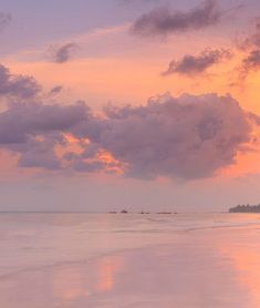 the sun is setting over the water at the beach