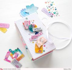 an open notebook with paper clips and tags on the cover, along with other items