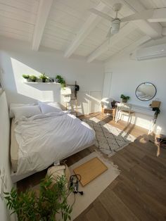 a bedroom with white walls and wooden floors