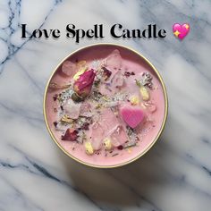 a pink bowl filled with lots of different types of candies on top of a marble table