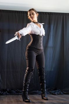 a woman dressed in black and white holding a knife