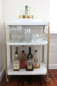 a bar cart filled with liquor bottles and glasses