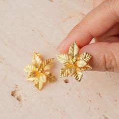 Get into the holiday spirit with our Joyful Poinsettia Stud Earrings, available in both warm gold-plated and sleek sterling silver. These earrings are inspired by the beloved poinsettia, the ultimate symbol of Christmas cheer and renewal. With their beautifully detailed petals and festive shine, they're the perfect little accessory to brighten up your holiday outfits or to give as a thoughtful gift. Whether you're going for the golden glow or the classic silver sparkle, these studs will add just Elegant Gold Earrings For The Holiday Season, Elegant Gold Earrings For Holiday, Gold Flower-shaped Earrings For Festive Occasions, Gold Jewelry For Festive Holiday Occasions, Gold Jewelry With Matching Earrings For Holiday, Gold Holiday Earrings For Party, Gold Flower Earrings For Festive Occasions, Gold Flower Earrings For Celebration, Gold Earrings For Party And Holiday