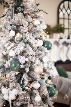 a white christmas tree with green and silver ornaments