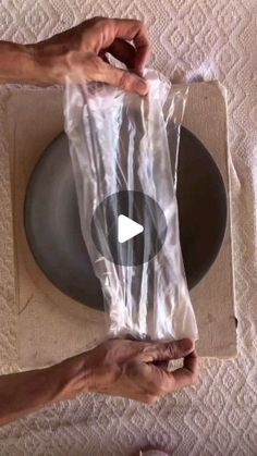 two hands holding a plastic bag on top of a plate