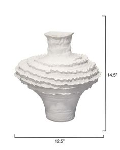 a white vase sitting on top of a table next to a tall ruler line with the measurements