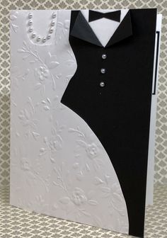 a black and white wedding card with a tuxedo in the back, on a patterned background