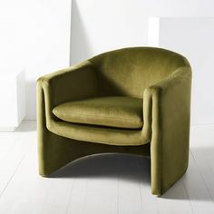 a green chair sitting on top of a white floor