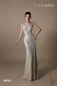 Steal the spotlight in the Tarik Ediz 96020 evening dress. Crafted from luxurious lace, this off-the-shoulder beauty with dazzling stones and delicate embroidery radiates elegance. The fitted bodice and mermaid-inspired skirt create allure, while the open back adds sophistication. Make heads turn at your next event. Silver Evening Dress, African Party Dresses, Chic Evening Dress, Silver Gown, Tarik Ediz, Evening Dress Fashion, Evening Dresses For Weddings, Bride Gowns, Mother Of The Bride Dresses