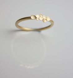 a gold ring with five small white dots on it