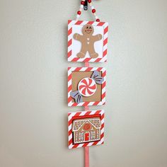 a christmas decoration hanging on the wall with candy canes and gingerbread house decorations