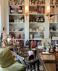 a living room filled with lots of furniture and bookshelves covered in figurines