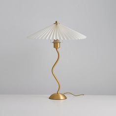 a lamp that is on top of a white table with a light bulb in the middle