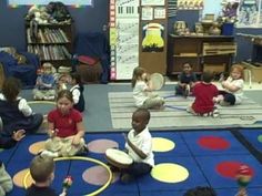 children sitting on the floor playing with their toys in a room full of other children