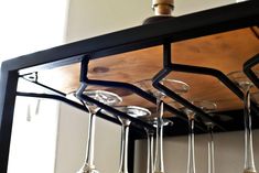 several wine glasses are hanging from a rack