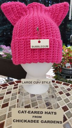 a pink knitted hat with ears on display