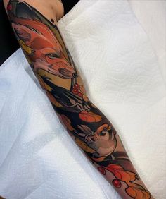 a person with a tattoo on their arm that has animals and birds on it, all in different colors