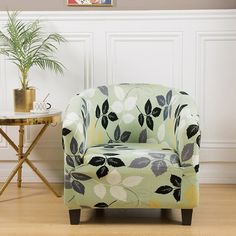 a green chair sitting next to a table with a potted plant