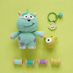 a crocheted stuffed animal next to some spools of thread and a keychain