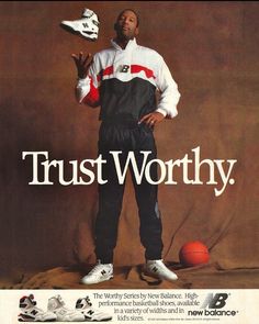 a man holding a basketball in his right hand while standing next to an orange ball