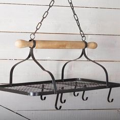 a metal rack with two hooks and a rolling board hanging from it's side