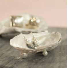 two oysters sitting on top of a wooden table next to each other with pearls in them