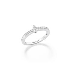 a white gold diamond ring with the word charmet written in cursive writing