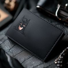 a black wallet with a batman face on it