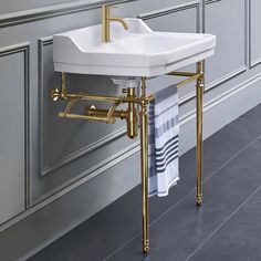 a white sink sitting on top of a metal stand next to a bath room wall