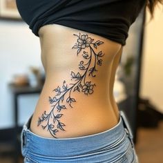 a woman's lower back tattoo with flowers on it