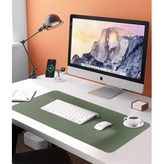 a computer monitor sitting on top of a desk next to a keyboard and mouse pad