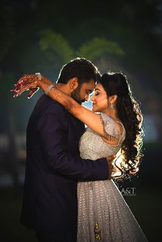 a bride and groom embracing each other in front of the light at their wedding reception