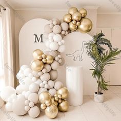 balloons are arranged in the shape of an arch with gold and white balls on it