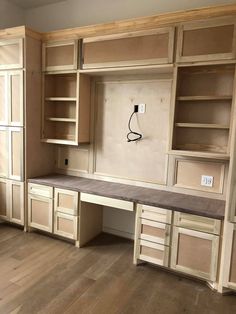 an empty room with wooden cabinets and shelves on the wall, including a bench that has been built into the wall