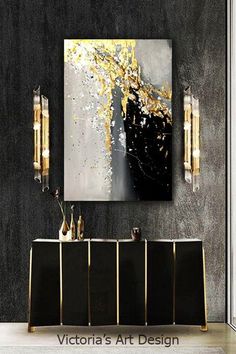 a black and gold living room with art on the wall, sideboard and vases