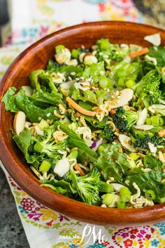 a wooden bowl filled with broccoli and nuts