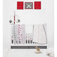 a white crib with red and gray decor