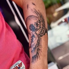 a person with a tattoo on their arm holding a cell phone in one hand and a skull in the other