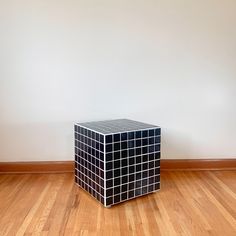 a black and white cube sitting on top of a hard wood floor