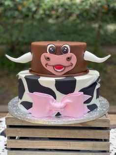 a three tiered cake with a cow design on top