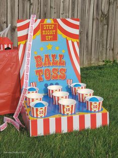 a circus themed birthday party with popcorn buckets and an orange bag on the grass