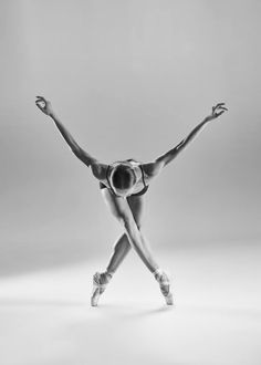 a black and white photo of a woman in ballet attire with her arms stretched out